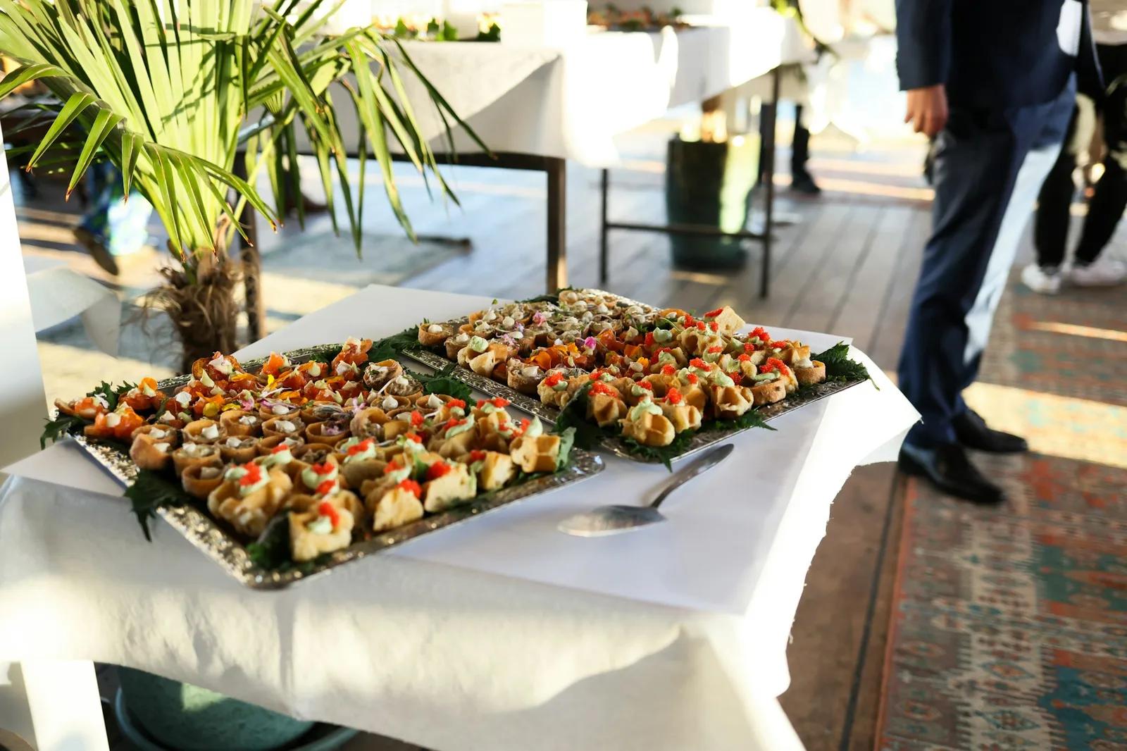 Δύο ασημένιοι δίσκοι με finger food σε λευκό τραπέζι κατά το καλωσόρισμα των καλεσμένων